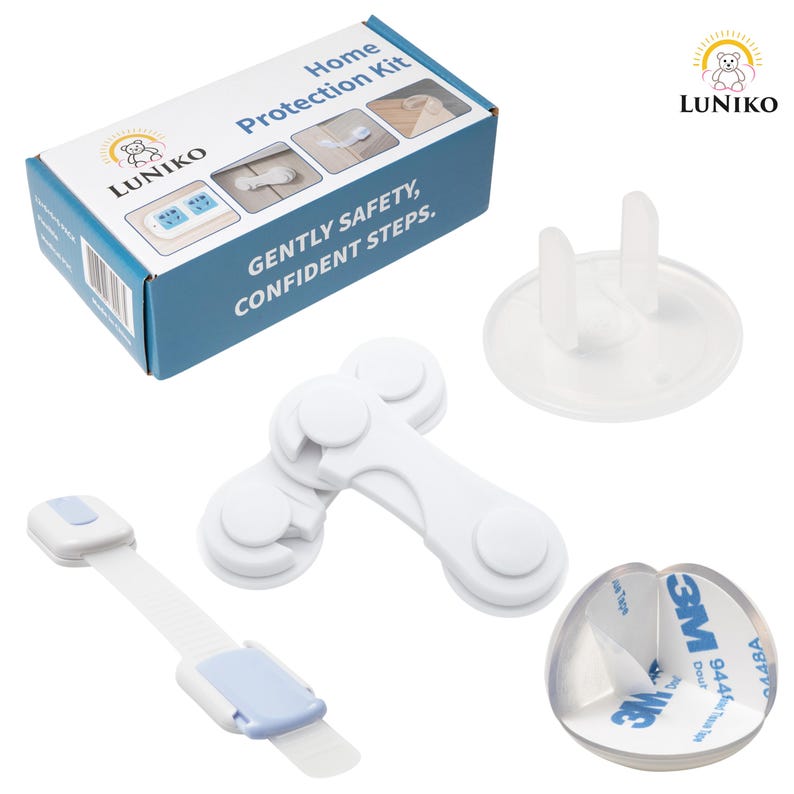 May include: A LUNIKO Home Protection Kit box with blue and white packaging, featuring child safety items including white plastic cabinet locks, a clear outlet plug cover, and a transparent corner guard with 3M adhesive backing.