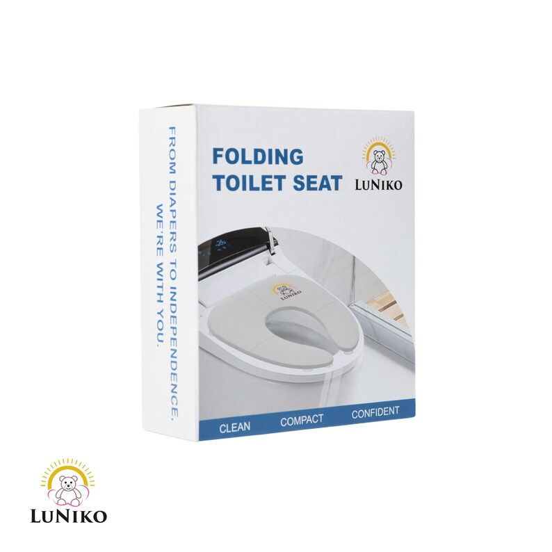May include: A white product box for a folding toilet seat by Luniko. The box features the text FOLDING TOILET SEAT, FROM DIAPERS TO INDEPENDENCE, WE'RE WITH YOU, CLEAN, COMPACT, CONFIDENT, and a graphic of a gray toilet seat with a bear logo.