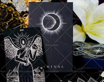 May include: Black tarot card deck with white celestial illustrations, including a crescent moon and sun design. The deck is labeled "ARRIVAL TAROT" and features the "Temperance" card. The cards are on a black surface.