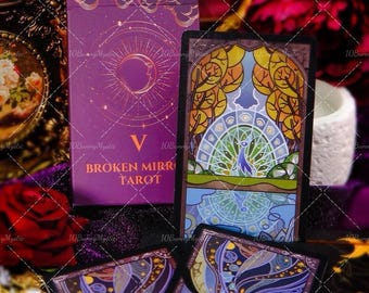 May include: A tarot card deck and several cards are displayed. The deck box is purple with gold accents and the text "Broken Mirror Tarot." The cards feature colorful, artistic illustrations with a celestial theme. The text "10BunnyMystic" is visible.