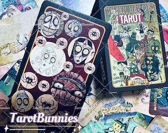 May include: A deck of Tarot cards with a black box featuring the text "SUPER HEROES PARODY TARUT". The cards have illustrations of cartoon characters with a dark, whimsical style. The cards are surrounded by other cards with similar illustrations. The text "Tarot Bunnies" is visible.
