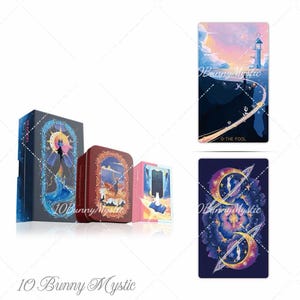 May include: A tarot card deck set featuring a dark blue box with a cat illustration, a red metal tin, and a small pink box. Two individual tarot cards are displayed: one titled 0-THE FOOL showing a lighthouse at sunset, and another with a cosmic design.