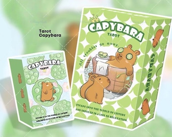 May include: Two green boxes of Capybara Tarot cards. The larger box features a capybara relaxing in a spa, with the text "All troubles go away." The smaller box has a capybara on a lily pad. The text "Escape into the world of leisure and indulge in a life of relaxation" is also visible.