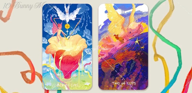 May include: Two tarot cards with colorful illustrations. The "Ace of Cups" card features a fairy figure and a large flower. The "Two of Cups" card depicts an angel-like figure with wings. The cards have a blue and purple background.