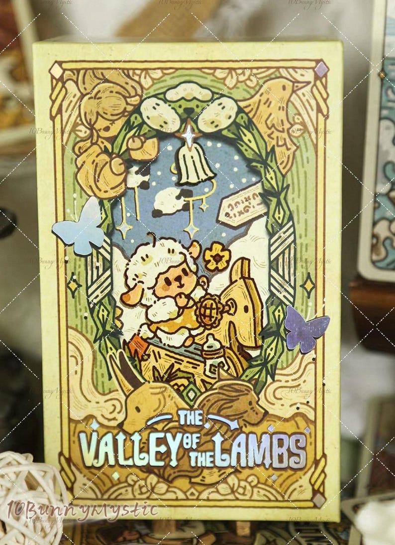 May include: A decorative card with a whimsical illustration. The card features a cartoon lamb riding a toy horse, surrounded by butterflies and the text "The Valley of the Lambs". The color palette includes yellow, blue, and green.