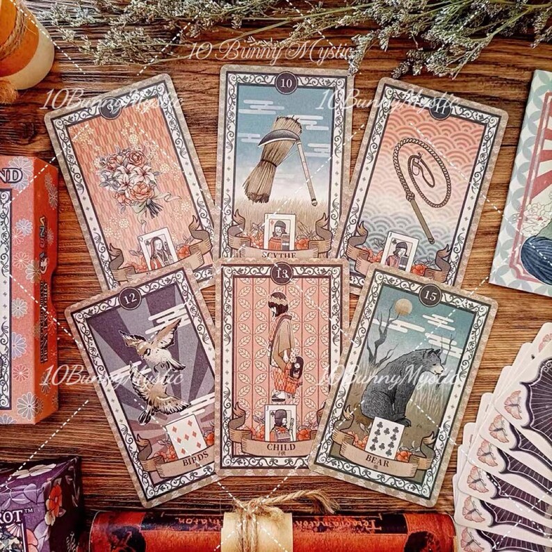 K&ouml;nnte beinhalten: Ein Set aus sechs rechteckigen Tarotkarten mit Illustrationen eines Blumenstrau&szlig;es, einer Sense, einer Peitsche, zwei V&ouml;geln, einem Kind und einem B&auml;ren. Jede Karte enth&auml;lt eine Nummer, einen dekorativen Rand und ein Banner mit Text wie Scythe, Child und Bear.