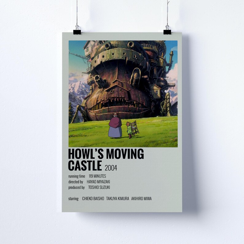 May include: Poster featuring the animated film "Howl's Moving Castle." The image showcases the castle, a large, mechanical structure, set against a green field and mountains. The poster includes the film's title, year, and credits.