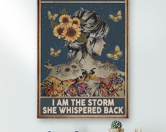 May include: A framed print featuring a woman's silhouette adorned with sunflowers and butterflies. The text reads, "THEY WHISPERED TO HER YOU CANNOT WITHSTAND THE STORM. I AM THE STORM SHE WHISPERED BACK." The artwork has a dark blue background.