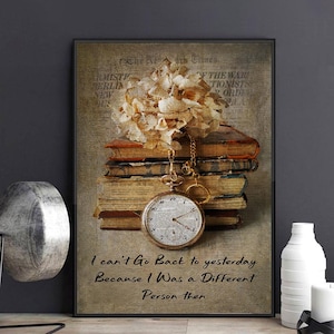 Pode incluir: Impressão emoldurada com estética vintage, mostrando uma pilha de livros antigos, um relógio de bolso e flores secas. O relógio está pendurado por uma corrente. A impressão inclui o texto: "I can't Go Back to yesterday Because I Was a Different Person then."