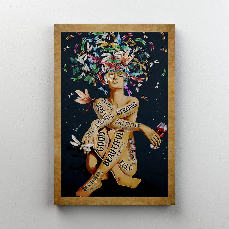 May include: A framed print depicting a seated figure with a crown of dragonflies in various colours. The figure's body is inscribed with words such as "Strong," "Beautiful," and "Good." The figure holds a glass of red wine against a dark backdrop.