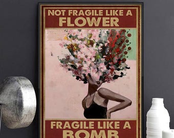 May include: Framed art print featuring a woman with a floral headpiece and the text "NOT FRAGILE LIKE A FLOWER, FRAGILE LIKE A BOMB." The artwork has a pink and red color scheme.