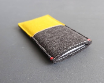 May include: A yellow and gray felt phone case with white stitching.