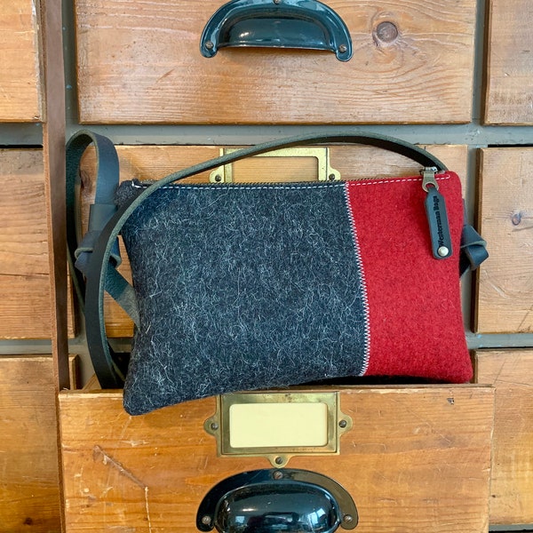 Small woolfelt crossbodybag. Minimalist design in pure wool, Zipper purse, leather handles. Red and black wool felt. Dutch Design Bags.