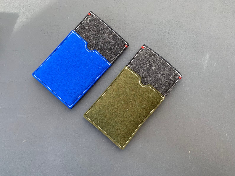 May include: Two felt phone cases, one blue and one green, with a black felt pocket on the front of each.