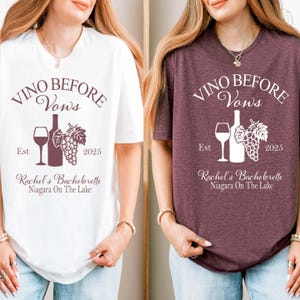 May include: Two short-sleeved t-shirts, one white and one burgundy, feature the text "VINO BEFORE VOWS" with a wine bottle, glass, and grapes graphic. The text "Rachel's Bachelorette Niagara On The Lake" is also printed on the shirts.