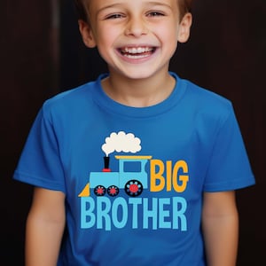 May include: A blue t-shirt with a cartoon train and the text "BIG BROTHER" in yellow and blue letters.
