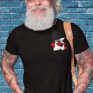 May include: A black t-shirt with a white and red Canadian flag design on the left chest. The flag is in the shape of Canada with the word "CANADA" underneath.