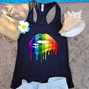 May include: A black tank top with a rainbow dripping lips graphic. The tank top is made of a soft, comfortable material.