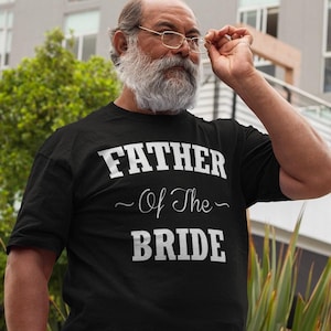 May include: A black t-shirt with white text that reads "Father of the Bride".