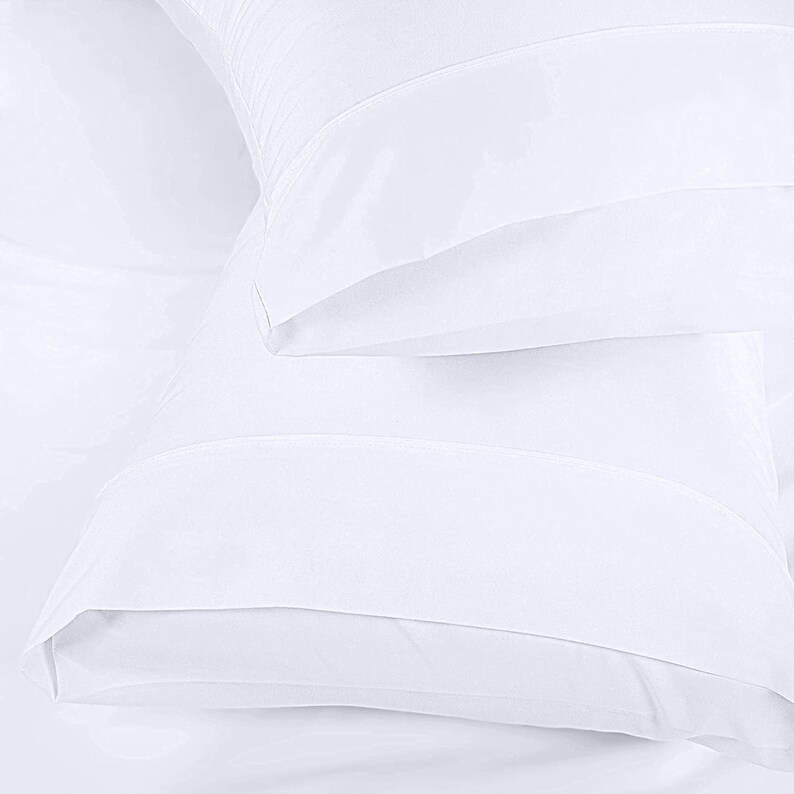 A close-up view of a white pillowcase or duvet cover, with a smooth and soft texture.