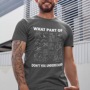 May include: A charcoal gray short-sleeved t-shirt featuring white text that reads WHAT PART OF followed by a collection of complex mathematical equations and graphs, with the text DON'T YOU UNDERSTAND printed in white at the bottom.