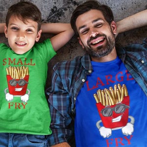 May include: A green t-shirt with a red carton of chips and the text SMALL FRY, and a blue t-shirt with a red carton of chips and the text LARGE FRY. Both shirts feature a cartoon chip carton with sunglasses and white gloves.
