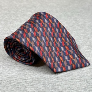 May include: Rolled navy blue tie with a repeating geometric pattern in red, gold, and purple. The tie is made of a silky material and is displayed on a gray surface. A classic accessory for formal or business attire.