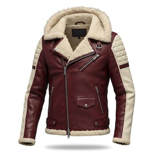 Peut inclure: Veste en cuir bordeaux avec capuche et col doublés de fausse fourrure crème. La veste présente des accents crème sur les épaules et les manches, une fermeture éclair sur le devant et plusieurs poches. La veste a un design matelassé sur les épaules.