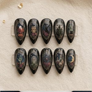 May include: A set of ten almond-shaped press-on nails with a glossy black finish. Each nail features a detailed oval frame containing unique illustrations including a ghost, owl, cat, haunted house, cauldron, hand, tombstone, spider, potions, and moon.