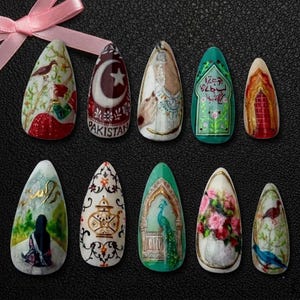 May include: A collection of ten almond-shaped nail art designs. Each nail features intricate, hand-painted artwork with themes including cultural motifs, landscapes, and floral arrangements. Colors include red, green, gold, and white, with some nails bearing text.