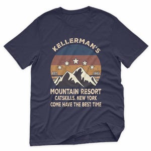 May include: Navy blue t-shirt with a retro design featuring the text "KELLERMAN'S MOUNTAIN RESORT CATSKILLS, NEW YORK" and a mountain graphic. The design includes stars and the year 1963. The shirt also says "COME HAVE THE BEST TIME".