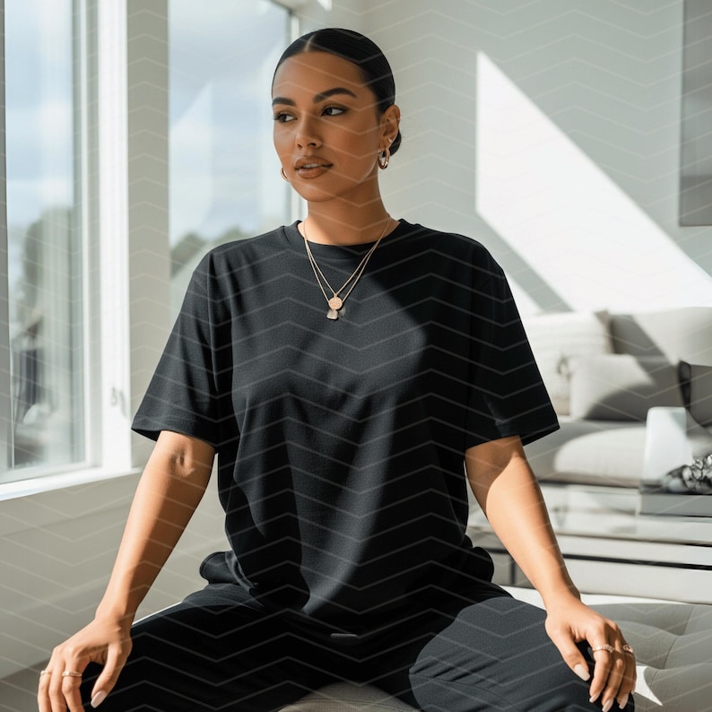 May include: A black t-shirt and black trousers. The person is wearing a gold necklace and rings. The outfit is simple and casual, suitable for everyday wear.