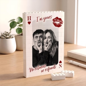 May include: A rectangular white building block frame featuring a black and white photograph of two people. The frame includes the red text "I'm yours" and "No returns or refunds," a red heart symbol with the letter H, a red kiss mark, and the letter N.