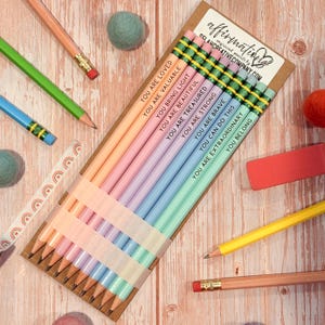 May include: A set of ten pastel-coloured pencils arranged on a cardboard backing, each featuring a unique affirmation text including You Are Loved, You Are Valuable, You Bring Light, You Are Beautiful, You Are Treasured, You Are Strong, You Are Brave, You Can Do This, You Are Extraordinary, and You Belong.