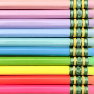 May include: A collection of ten wooden pencils arranged horizontally in a gradient pattern. Each pencil features a smooth pastel or bright colored barrel, a metallic green ferrule, and a small eraser at the end of the pencil shaft.