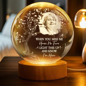 May include: A glowing glass sphere with a photo of a woman, set on a wooden base. The sphere has etched tree and bird designs, with the text "WHEN YOU MISS ME Have No Fear LIGHT THIS UP AND KNOW I'm Here".