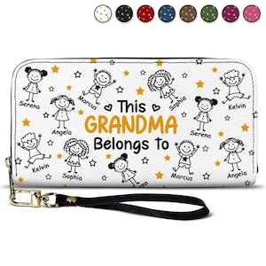 May include: White zip-up purse with a black wrist strap. The purse features a design with cartoon figures, stars, and the text "This GRANDMA Belongs to". The names Serena, Marcus, Angela, Kelvin, and Sophia are also displayed.