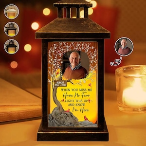 May include: A bronze memorial lantern featuring a photograph and the text "WHEN YOU MISS ME Have No Fear LIGHT THIS UP AND KNOW I'm Here." The lantern emits a warm, inviting light.