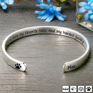 Pode incluir: Pulseira de punho prateada com a inscrição gravada "You Were My Favorite Hello And My Hardest Goodbye". Apresenta uma pegada e o nome "Max". Uma joia comemorativa.