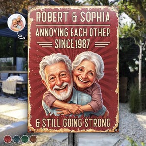 Può includere: Una targa rettangolare in metallo con sfondo rosso usurato e un motivo a raggiera. Riporta il testo ROBERT & SOPHIA, ANNOYING EACH OTHER SINCE 1987 e & STILL GOING STRONG. Al centro è presente l'illustrazione di una coppia anziana che si abbraccia.