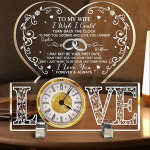 Puede incluir: Un reloj decorativo con un diseño en forma de corazón y las palabras "TO MY WIFE" y "I Love You Forever & Always." La esfera del reloj es dorada con números romanos negros. La palabra "LOVE" está escrita debajo.