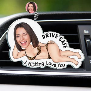Könnte beinhalten: Auto-Luftauslass-Dekoration mit einer Cartoon-Illustration einer Frau in einem Bikini mit Leopardenmuster. Der Text "DRIVE SAFE" und "I F**king Love You" sind im Design enthalten. Ein kleineres Bild der Frau ist ebenfalls enthalten.
