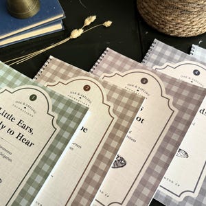 May include: A set of five spiral-bound educational workbooks with gingham patterned covers in shades of green, tan, brown, and gray. Each cover features a decorative label with the text Oak & Sapling Foundations and a detailed insect illustration.