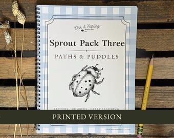 May include: A spiral-bound workbook titled Sprout Pack Three Paths & Puddles with a light blue gingham border and a black and white ladybug illustration. The cover features the text Letters, Numbers, Early Learning and a Printed Version banner.