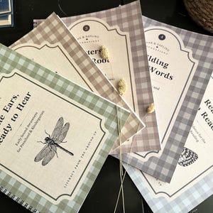 May include: A set of five spiral-bound educational workbooks with gingham patterned covers in sage green, tan, brown, gray, and light blue. Each cover features a decorative label with the text Oak & Sapling Foundations, numbered titles, and illustrations.