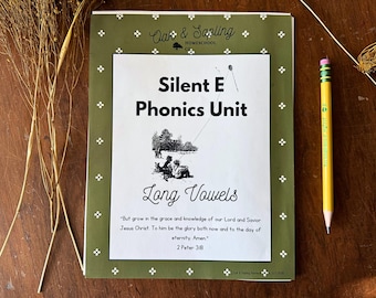 May include: A rectangular educational workbook titled Silent E Phonics Unit Long Vowels with an olive green border featuring white floral accents. The cover includes a black and white illustration of children flying a kite and a Bible verse.