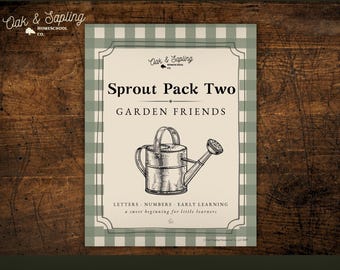 May include: A framed print with a green and white gingham border. The print features the text "Sprout Pack Two GARDEN FRIENDS" and an illustration of a watering can. The print also includes the text "LETTERS NUMBERS EARLY LEARNING a sweet beginning for little learners."