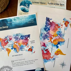 Peut inclure: Impressions de cartes du monde &agrave; l'aquarelle avec les oc&eacute;ans &eacute;tiquet&eacute;s, dont le Pacifique, l'Atlantique et l'Indien. Le texte "In Oceans Deep" et un verset biblique sont visibles. Un plan de le&ccedil;on intitul&eacute; "Lesson Three Paths of the Seas" est &eacute;galement pr&eacute;sent.