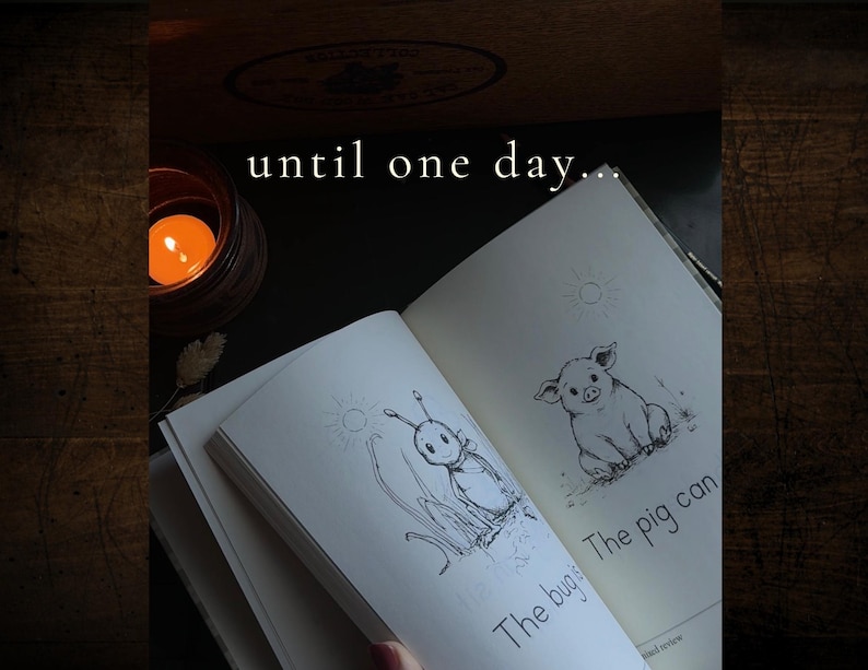 Puede incluir: Un libro abierto con ilustraciones de l&iacute;neas en blanco y negro de un insecto y un cerdo, con el texto "until one day...", "The bug" y "The pig can" impreso en las p&aacute;ginas, acompa&ntilde;ado de una peque&ntilde;a vela encendida en un portavelas.