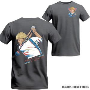 May include: Dark heather gray t-shirts with a golf-themed graphic. One shirt features a golfer swinging a club with "GRIP IT & RIP IT" text. The other shirt has a smaller graphic of the golfer and text.